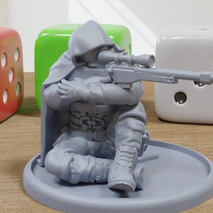 May include: A grey plastic miniature figurine of a hooded figure holding a rifle, sitting on a grey base. The figure is wearing a hooded cloak and is holding a rifle with a scope.