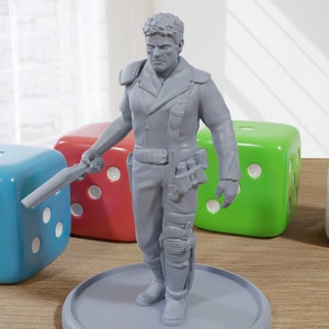 Könnte beinhalten: Eine graue Plastik-Miniaturfigur eines Mannes, der eine Jacke und eine Hose trägt. Er hält eine Waffe in seiner rechten Hand und hat ein mechanisches Bein. Die Figur steht auf einem grauen Sockel.