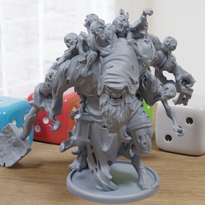 Puede incluir: Una miniatura gris de un monstruo zombie impresa en 3D con varios zombies más pequeños aferrándose a ella. El monstruo sostiene una pala en su mano derecha y tiene un paño desgarrado drapeado sobre su cabeza. La miniatura está sobre una base redonda.