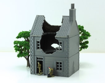 May include: A gray, two-story, miniature model of a destroyed building with a missing roof and a large hole in the side. Two miniature figures stand in front of the building.