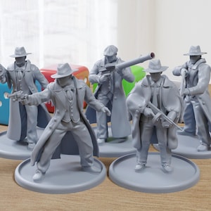 Op de afbeelding: Vijf grijs geverfde miniatuurfiguren van mannen die fedora's en trenchcoats dragen. Elk figuur houdt een wapen vast en staat op een ronde basis.