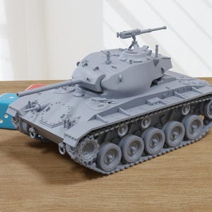 Peut inclure: Un modèle gris d'un char avec une tourelle de canon et des chenilles. Le char est sur une surface en bois.