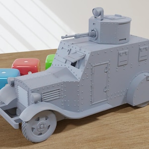 May include: A gray toy armored car with a machine gun turret on top. The car is on a wooden surface with three colorful toy blocks in the background.