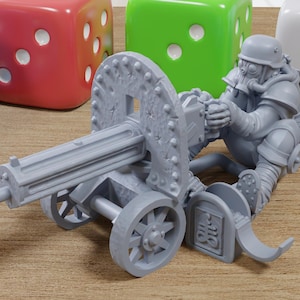 May include: A gray miniature of a soldier operating a machine gun, with a helmet and gas mask, surrounded by colorful dice. The machine gun is mounted on a wheeled carriage. The dice are blue, red, green, and white.