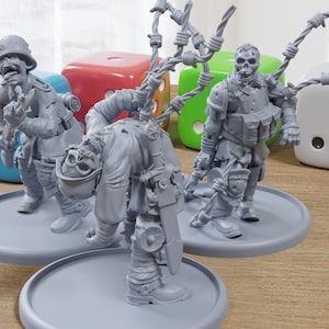 May include: Three gray miniature zombie figures with military-style gear and barbed wire accents stand on gray circular bases. Dice in blue, red, green, and white are in the background. The figures have skull-like faces.