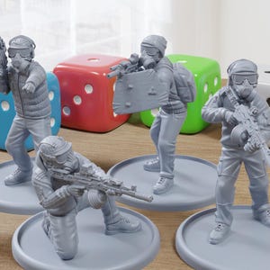 May include: A collection of gray figurines depicting soldiers in gas masks and tactical gear, each mounted on a circular base. The figures are posed with weapons, and colorful dice are in the background.