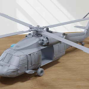 Könnte beinhalten: Graues Modell eines Hubschraubers mit detaillierten Merkmalen, darunter Cockpit, Rotorblätter und Heckrotor. Das Modell wird auf einer Holzoberfläche präsentiert, die sein Design und seine Struktur zeigt. Das Hubschraubermodell ist eine detaillierte Nachbildung.