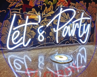 May include: White neon sign with the text "Let's Party" on a floral background. The sign is illuminated and casting a reflection on the floor.