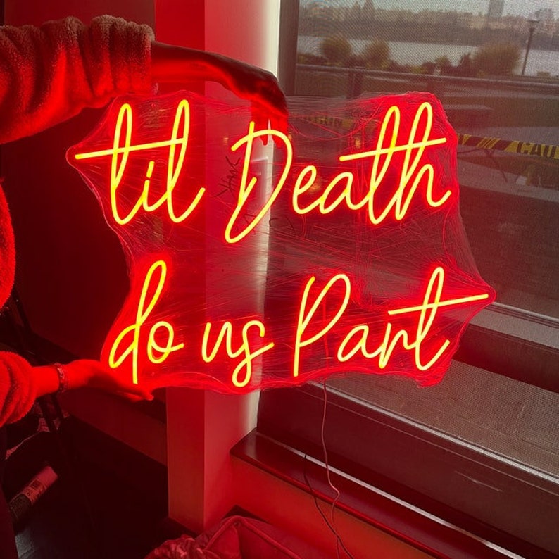 Op de afbeelding: Een neonbord met de woorden "til Death do us Part" in gele letters op een rode achtergrond.