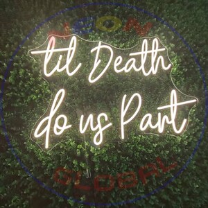 Op de afbeelding: Een wit neonbord met de tekst "til death do us part" in een cursief schrift. Het bord is verlicht en hangt aan een groene muur.