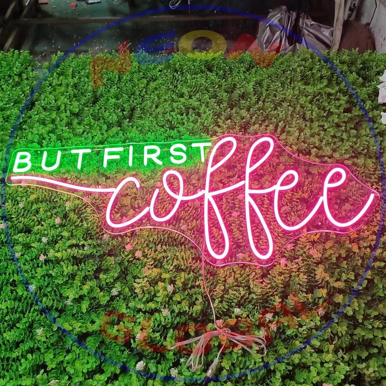 May include: Neon sign with the text "But first, coffee" in pink and green. The sign is on a green background.