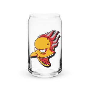 May include: A clear glass can featuring a cartoon image of a yellow character with red hair and a mischievous expression. The character has a large nose and a wide open mouth.