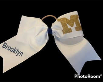 Customized white grosgrain ribbon with team logo and personalized cheerleader’s name