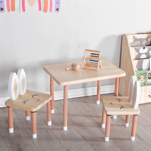 Handcrafted wooden kids table and chair set in natural finish, perfect for play and study. The table features a rectangular top with rounded corners, accompanied by two matching chairs with comfortable, ergonomic seats.