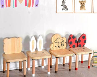 May include: Four wooden children's chairs with different animal and cloud designs. The chairs are painted in various colours, including red, white, and brown. The chairs are all made of wood and have a simple, sturdy design.