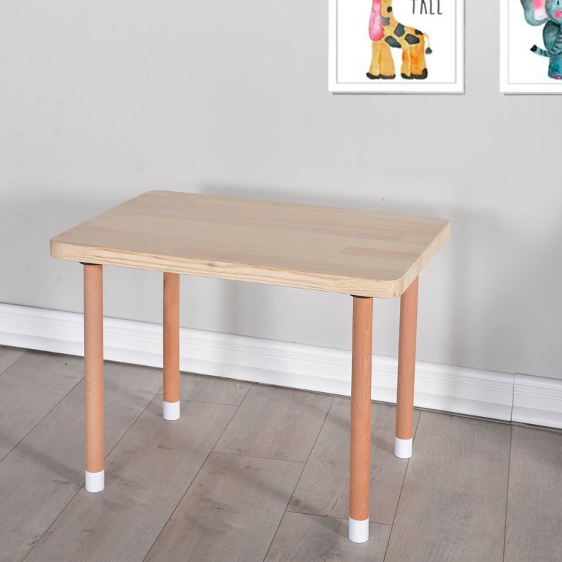 Handcrafted wooden kids table and chair set in natural finish, perfect for play and study. The table features a rectangular top with rounded corners, accompanied by two matching chairs with comfortable, ergonomic seats.