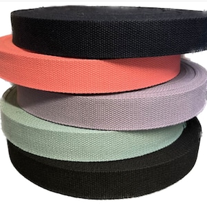 Pode incluir: Um conjunto de quatro correias de cinta de algodão em preto, coral, lavanda e verde claro.