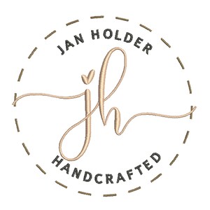 May include: A logo with the text "Jan Holder Handcrafted" in a circle with a dashed line border. The letters "jh" are in a cursive font with a heart in the center of the "j".