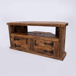 May include: A corner TV stand made of reclaimed wood with two doors and a shelf. The stand has a dark brown stain and black metal hinges and handles.