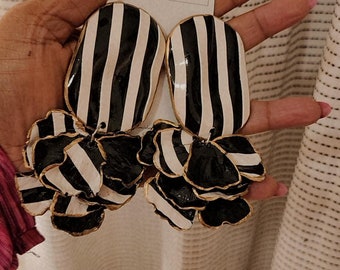 Beautifully designed clay earrings. Each pair is hand-crafted with polymer clay and coated in resin. Black and white stripes with flower