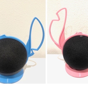 May include: Two blue and pink Stitch-themed stands for a smart speaker. The stands are shaped like Stitch's ears and have a base that matches the color of the ears.