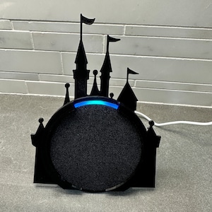May include: A black silhouette of a castle with a blue light ring around a black speaker.