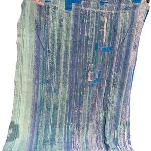May include: A blue, green, and white patterned textile with vertical stripes and patches of color. The fabric appears to be a quilt or blanket, with a textured, worn appearance. The color palette includes shades of blue, green, and pink.