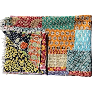 Könnte beinhalten: Ein farbenfrohes Patchwork-Textil mit einer Vielzahl von Mustern und Farben. Das Textil zeigt Quadrate aus verschiedenen Stoffen, darunter Blumen- und geometrische Designs. Die Kanten sind mit Fransen versehen. Die Farbpalette umfasst Rot, Grün, Orange und Blau.