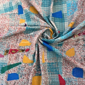 Puede incluir: Textil de patchwork con una mezcla de colores y patrones. La tela presenta tonos turquesa y rosa, superpuestos con cuadrados y parches azules, amarillos y rojos. El diseño incluye detalles cosidos y una variedad de texturas.