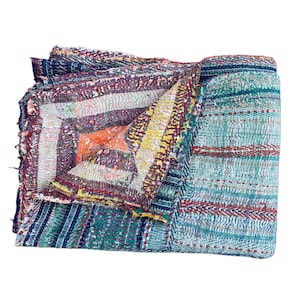 May include: Folded, multi-colored quilt with a patchwork design. The quilt features a variety of colors, including teal, red, yellow, and orange. The stitching is visible, adding texture. The quilt is folded neatly, showcasing its intricate patterns.