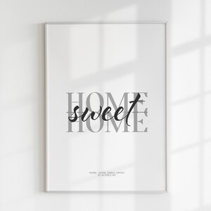 A close-up of a framed home sweet home print with soft window light and shadows across it.