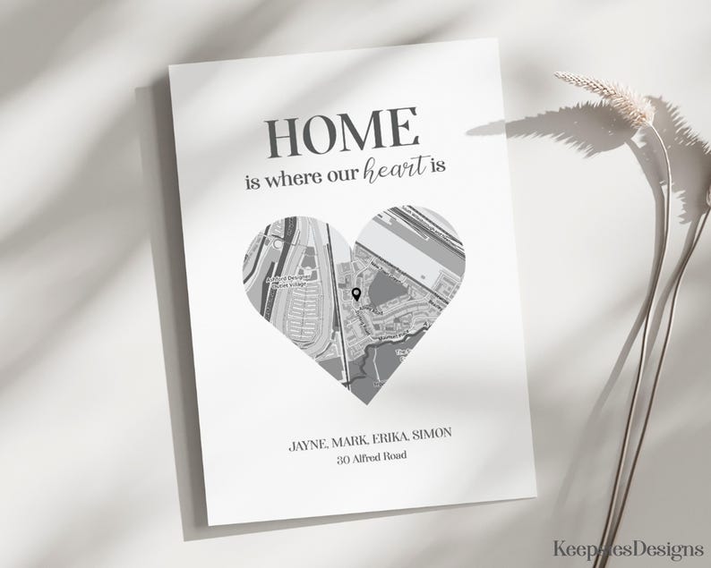Pode incluir: Impress&atilde;o a preto e branco com um mapa em forma de cora&ccedil;&atilde;o e o texto "HOME is where our heart is". Nomes e um endere&ccedil;o est&atilde;o abaixo do cora&ccedil;&atilde;o. O papel &eacute; branco.