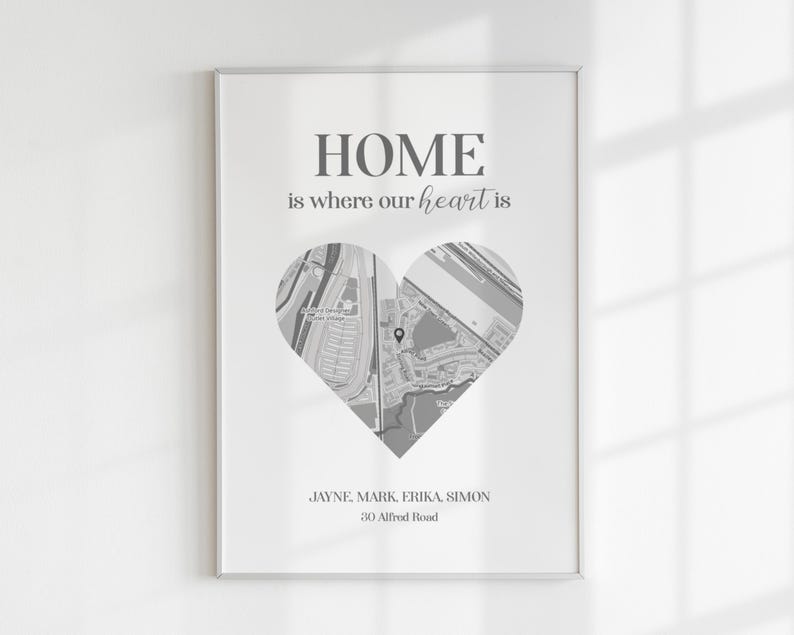 Pode incluir: Impress&atilde;o emoldurada com o texto "HOME is where our heart is". Um mapa em forma de cora&ccedil;&atilde;o est&aacute; centrado abaixo do texto. Os nomes Jayne, Mark, Erika e Simon s&atilde;o listados abaixo, juntamente com o endere&ccedil;o 30 Alfred Road.