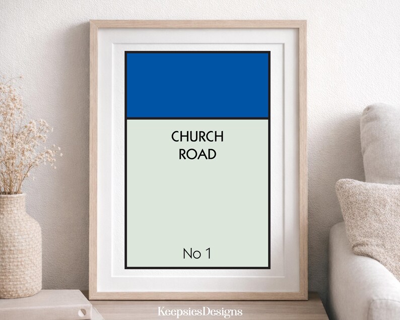 May include: A framed vertical wall art print featuring a blue rectangular block at the top over a light cream background. The text CHURCH ROAD is printed in black in the centre, with No 1 printed in black at the bottom, all inside a light wood frame.