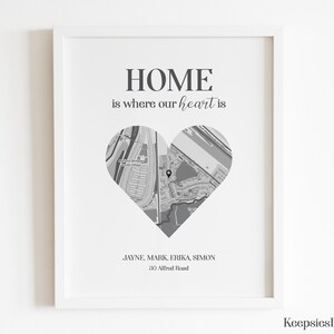 Pode incluir: Uma impress&atilde;o emoldurada com o texto "HOME is where our heart is". Um mapa em forma de cora&ccedil;&atilde;o est&aacute; no centro. Abaixo do cora&ccedil;&atilde;o est&atilde;o nomes e um endere&ccedil;o. A impress&atilde;o est&aacute; em uma moldura branca.