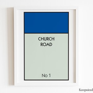 May include: A framed wall art print featuring a rectangular design with a solid blue top section and a light grey bottom section. The text CHURCH ROAD is printed in black in the centre, with No 1 printed in black at the bottom of the print.