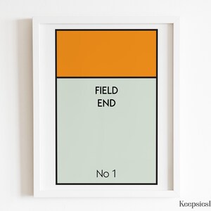 May include: A framed rectangular print featuring a solid orange horizontal bar at the top, followed by a light grey section containing the black text FIELD END and the text No 1 at the bottom, all enclosed within a simple white frame.