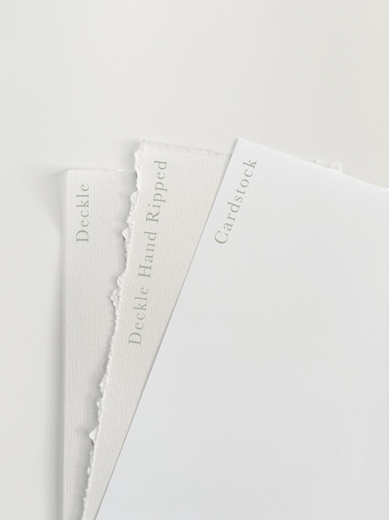 May include: Close-up of two white paper samples. The sample on the left has a deckle edge and is labelled "Deckle". The sample on the right has a smooth edge and is labelled "Cardstock". The sample in the middle has a deckle edge and is labelled "Deckle Hand Ripped".