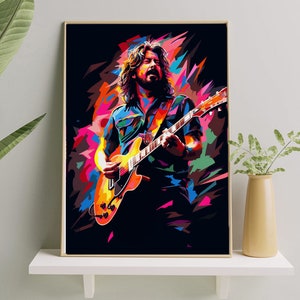 Puede incluir: Una impresión enmarcada de estilo pop art de un músico tocando la guitarra. La obra de arte presenta colores vibrantes, incluyendo naranja, amarillo, azul y rosa, sobre un fondo negro. El músico está representado con pelo largo y barba, vistiendo una camisa azul.