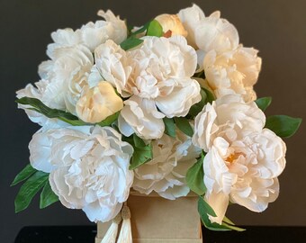 Silk floral arrangement with white peonies in the box with tassels.