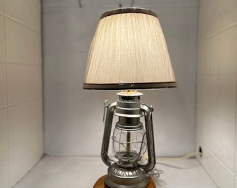 recycled oil lantern, made into a home made lamp. The base is made from a cedar limb that came off in a storm. No shades or bulbs included.