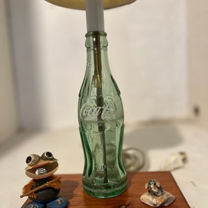 Home made nite lite out of a recycled old 6 1/2 oz coke bottle. It has a couple of home made sea shell characters with it.