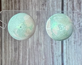 Green and white round concrete stud earrings with shimmering mica powder