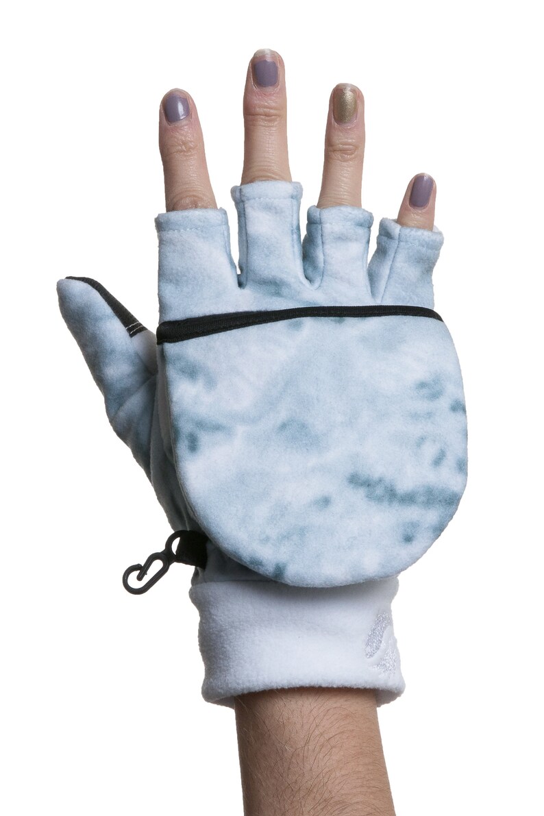 K&ouml;nnte beinhalten: Ein Paar blaue und wei&szlig;e fingerlose Handschuhe mit Fleecefutter und einer schwarzen Rei&szlig;verschlusstasche auf der R&uuml;ckseite der Hand.