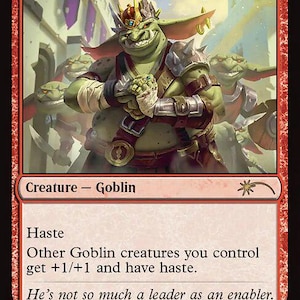 May include: A red Magic: The Gathering card named "Goblin Chieftain." The card depicts a green goblin with a crown, armour, and a menacing grin. Text includes "Haste" and "Creature - Goblin." The card's power and toughness are 2/2.