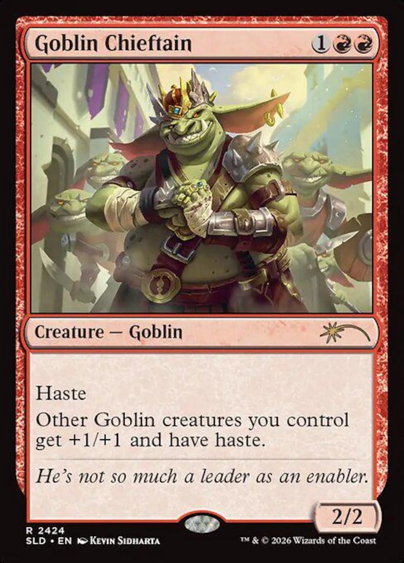 May include: A red Magic: The Gathering card named "Goblin Chieftain." The card depicts a green goblin with a crown, armour, and a menacing grin. Text includes "Haste" and "Creature - Goblin." The card's power and toughness are 2/2.