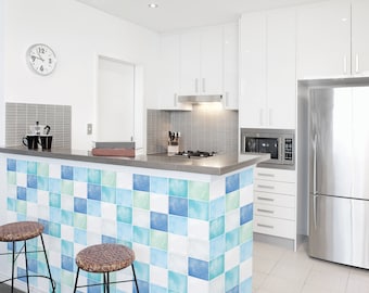May include: A kitchen island with a white countertop and a backsplash of blue and green square tiles. The island has two bar stools with woven seats. There is a stainless steel refrigerator and a microwave in the background.