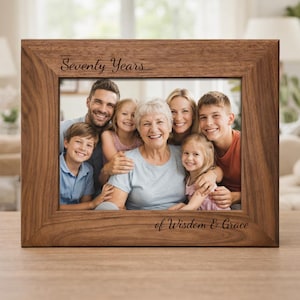 May include: A rectangular wooden picture frame with a family portrait. The frame has the words "Seventy Years" and "of Wisdom & Grace" engraved on it. The photo shows a smiling family of seven.