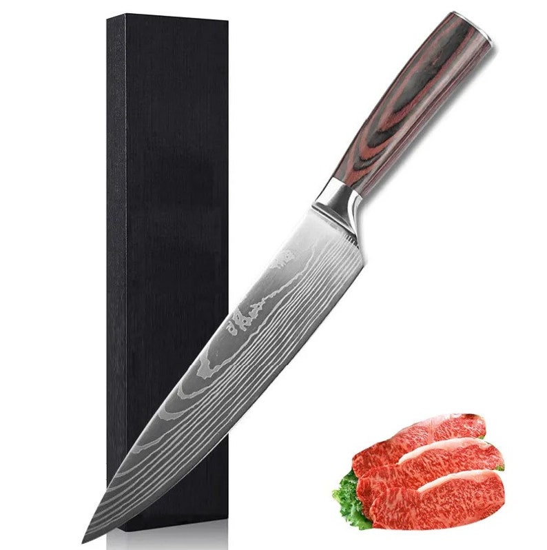 May include: A silver chef's knife with a black wood handle and a Damascus steel blade. The knife is resting on a black wooden block. The knife is sharp and has a pointed tip. The knife is surrounded by a white background.