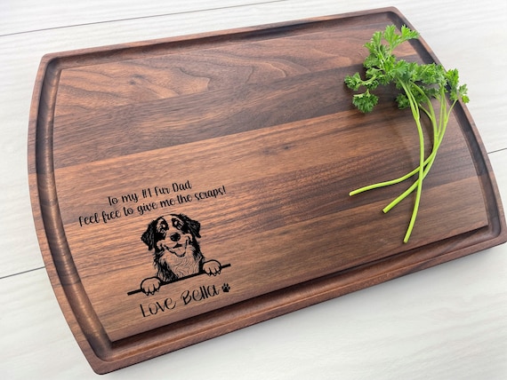 A laser-engraved cutting board shaped around a Bernese Mountain Dog portrait — niche breed specificity makes it feel genuinely made for *that* dog owner.